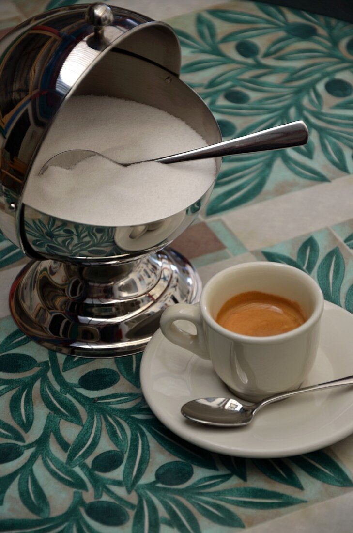 An espresso and a sugar pot