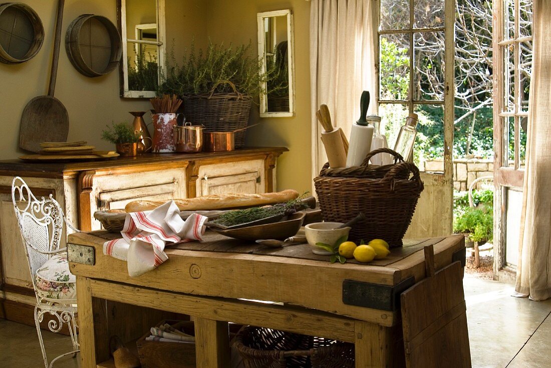Kitchen utensils, lemons, baguette and lavender on a rustic wooden table