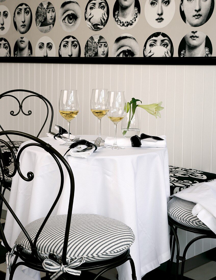 A bistro table laid in black and white with glasses of aperitif