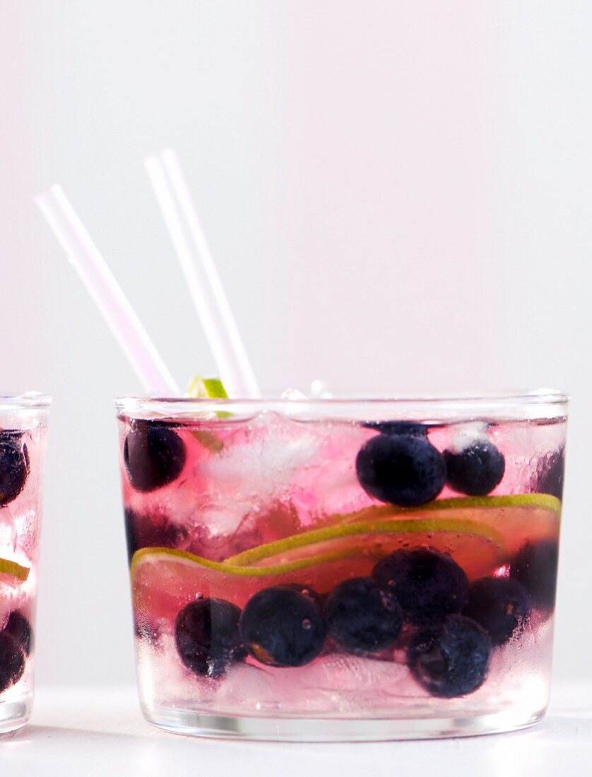 Cocktail mit Gin, Tonic Water, Heidelbeeren und Limetten