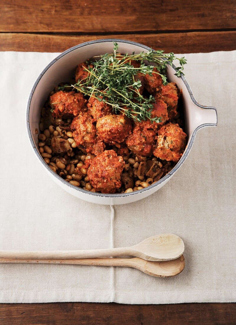 Meatballs with a tomato and garlic sauce on a bed of beans