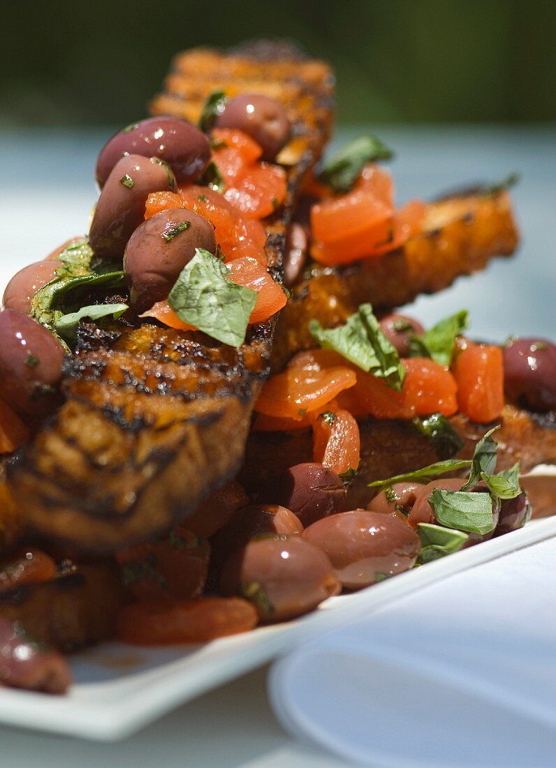 Grilled ciabatta slices with tomato and olive salsa and mint