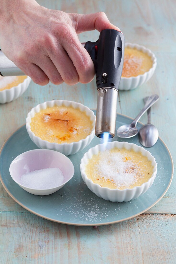 Crème brûlée being caramelised with a Bunsen burner