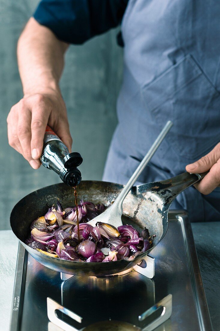 Steamed red onions being quenched with soy sauce