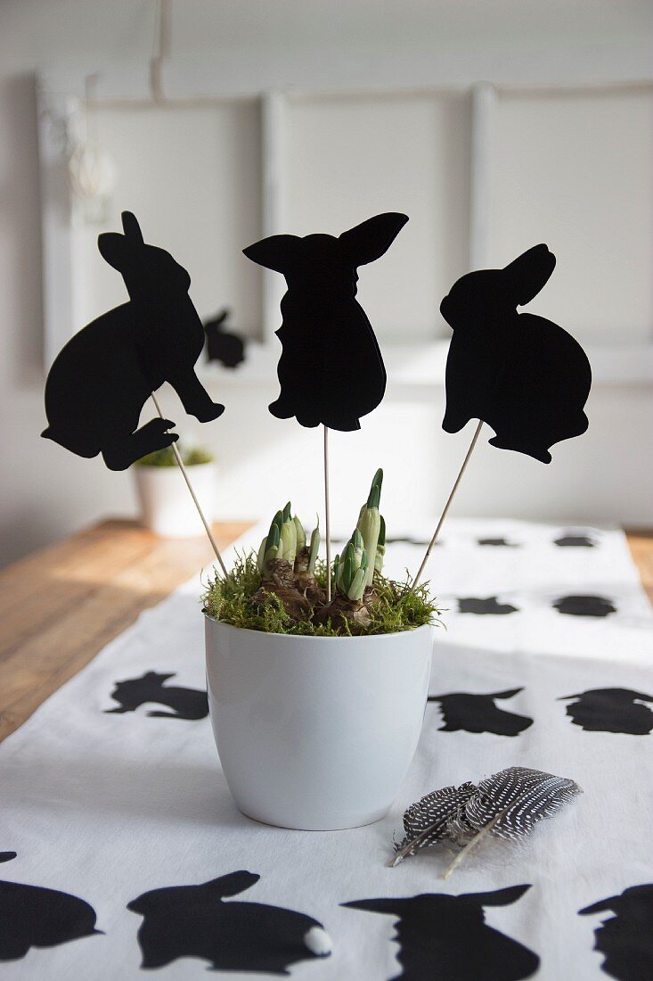 Rabbit-shaped plant pot decorations on Easter table
