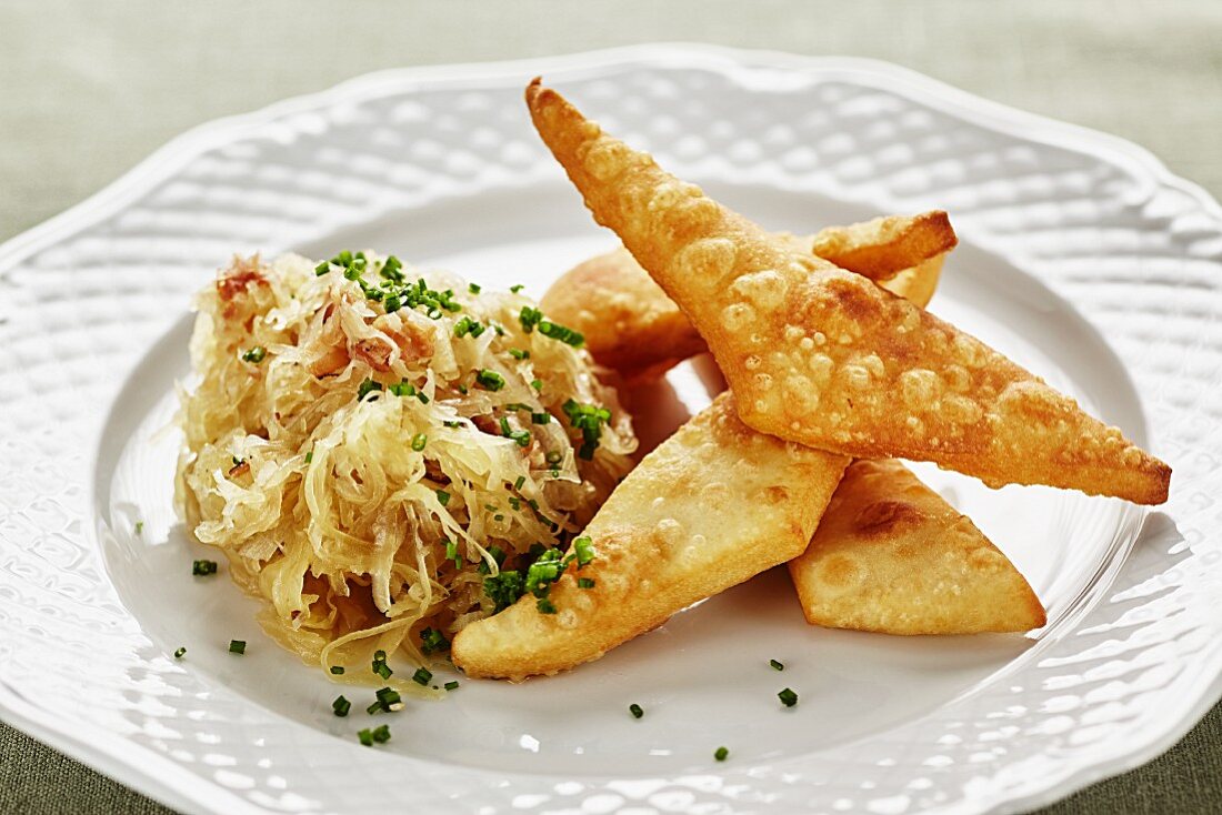 Blattlkrapfen (deep-fried batter cakes, Austria) with bacon and cabbage salad