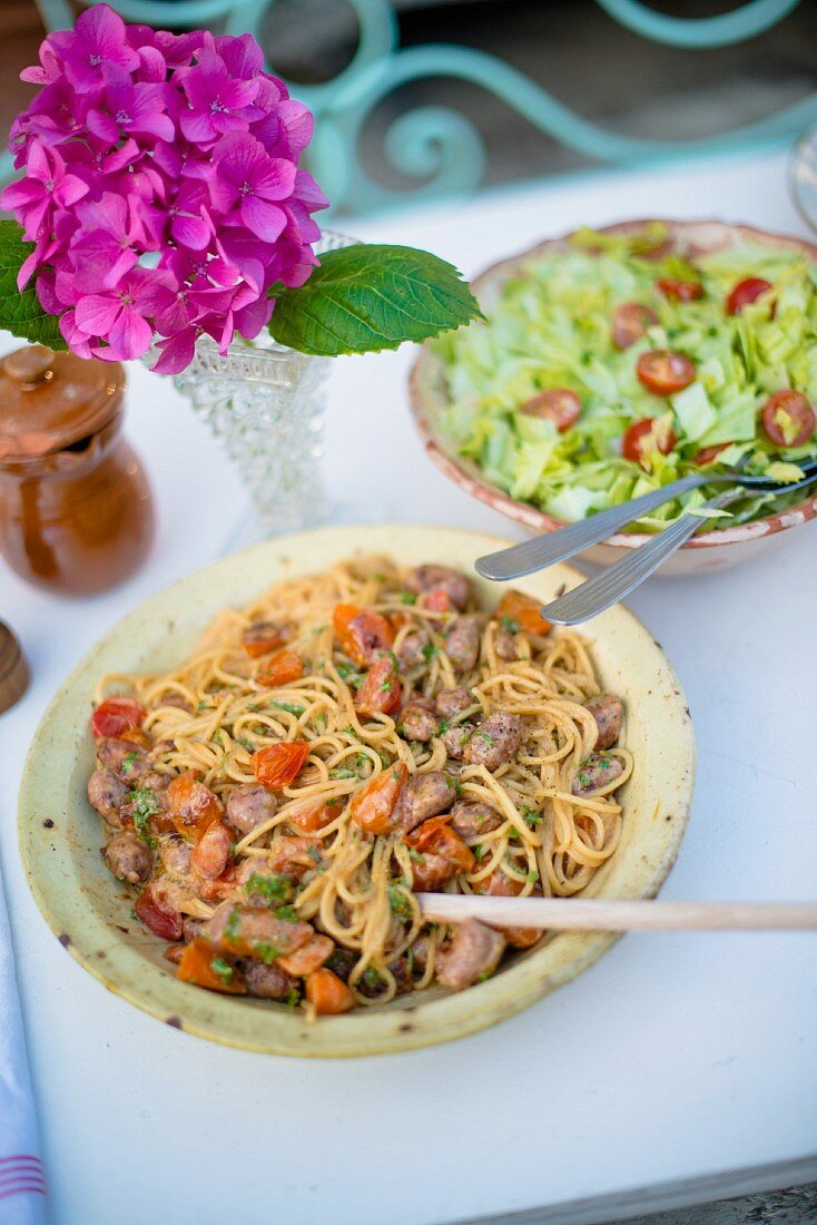 Spaghetti mit Fleischbällchen und grüner Salat mit Kirschtomaten