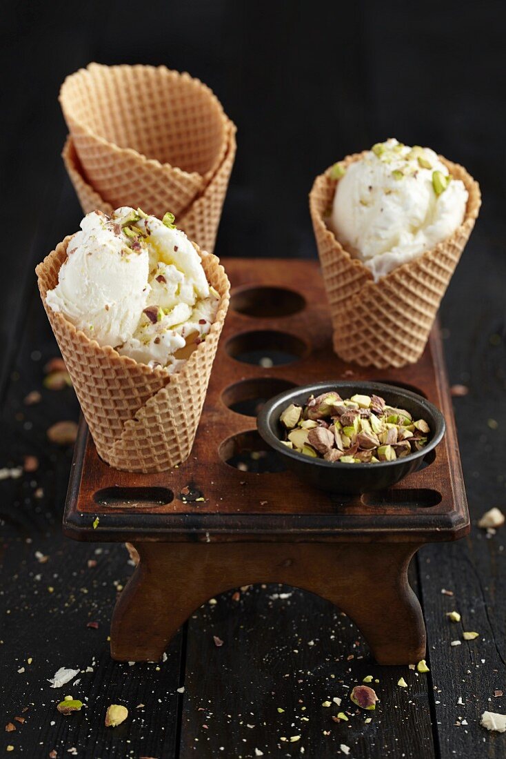Nut ice cream in ice cream cones in an old egg holder on a dark wooden table
