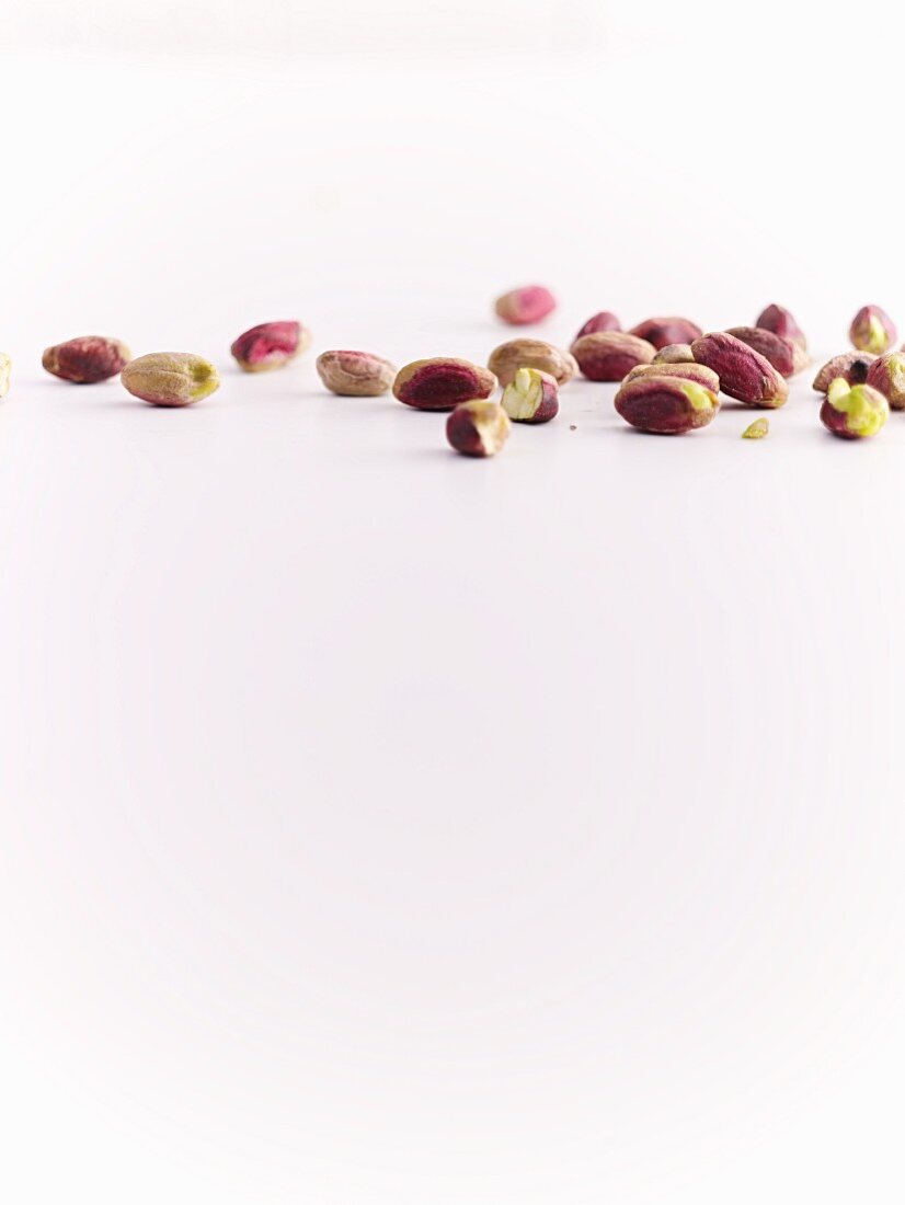 Pistachio nuts on a white surface