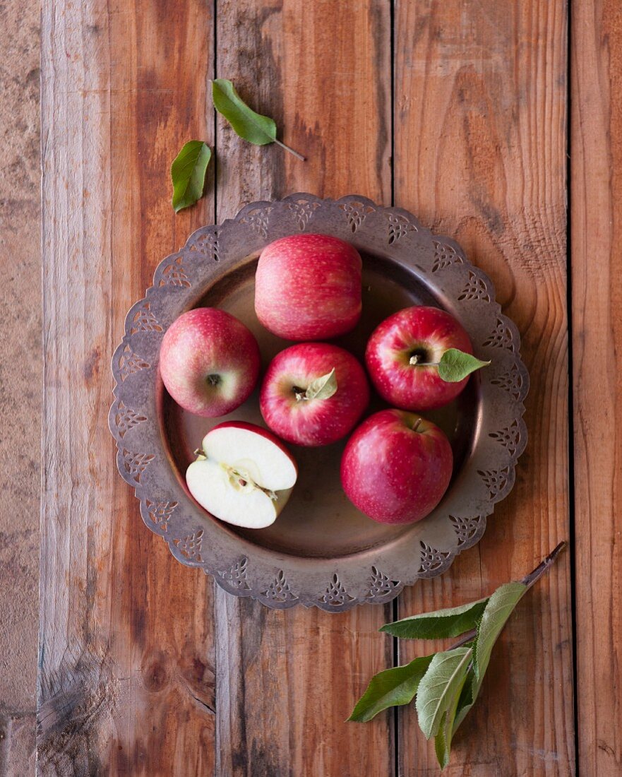 Red apples on a metal plate (seen from above)