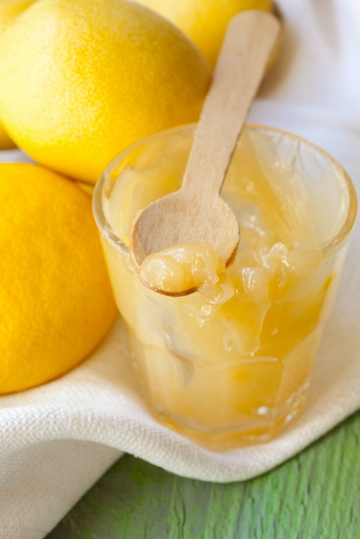 A jar of lemon curd with lemons