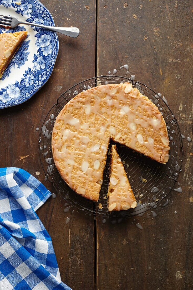 Freshly baked Bakewell tart, sliced, on a cooling rack