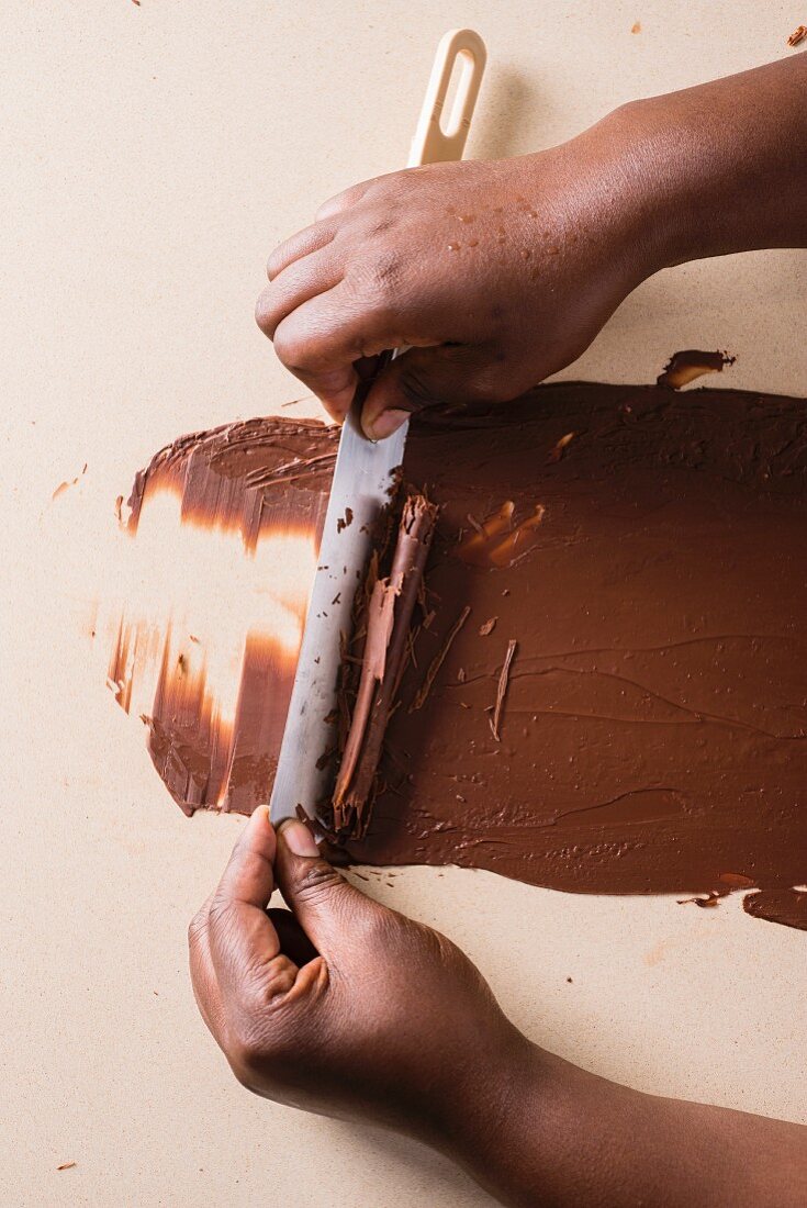Chocolate rolls being scraped with a knife