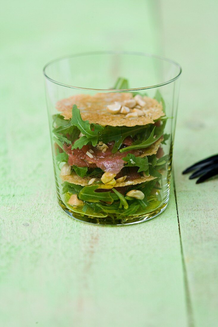 Rinderfilet-Carpaccio mit Haselnüssen, Parmesanchips und Rucola im Glas