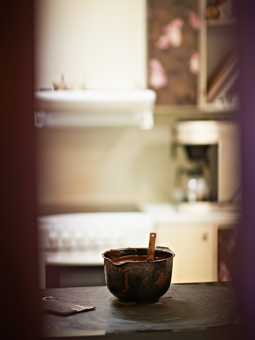 A bowl of liquid chocolate in a kitchen