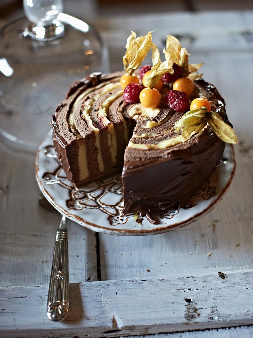 Chocolate cake with physalis and raspberries, sliced