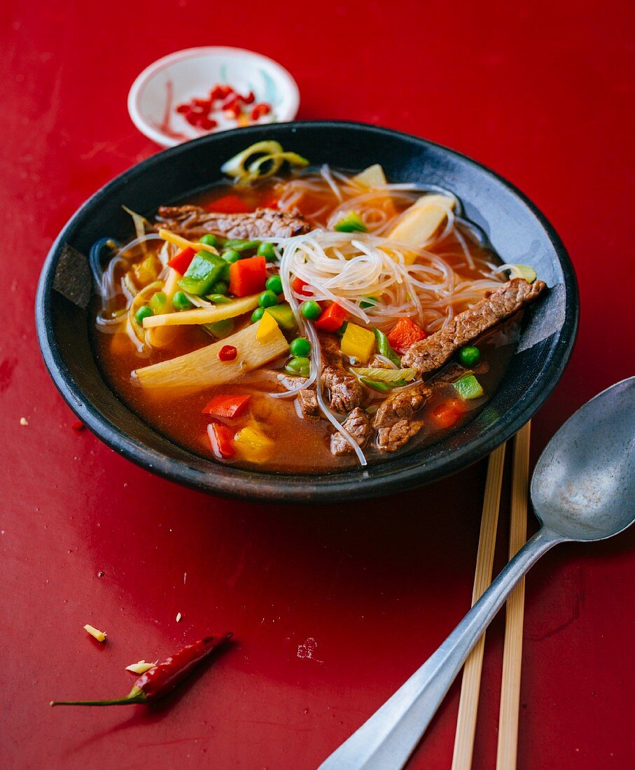 Spicy glass noodle soup with beef, ginger and peppers