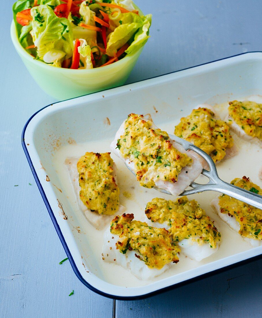 Gratinated fish fillets with a herb crust and a side salad