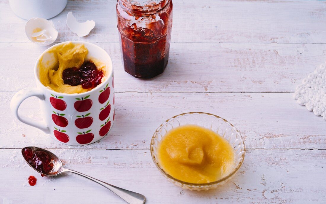 A mug cake: unbaked cake mixture with jam in a mug