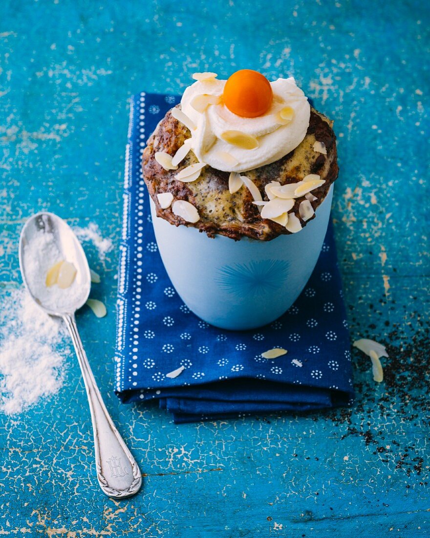 A white chocolate mug cake with poppyseeds and a mascarpone topping