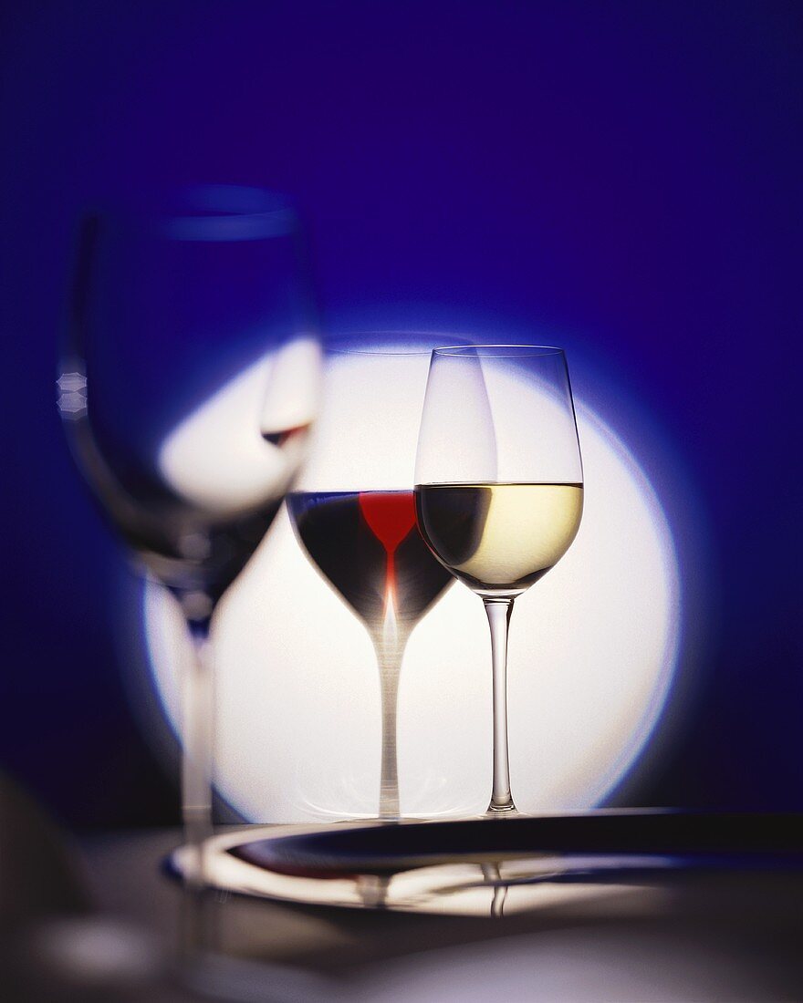 Three different wine glasses in front of a circle of light