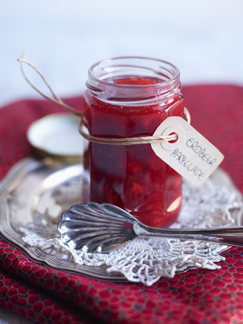 A jar of strawberry jam with a tag