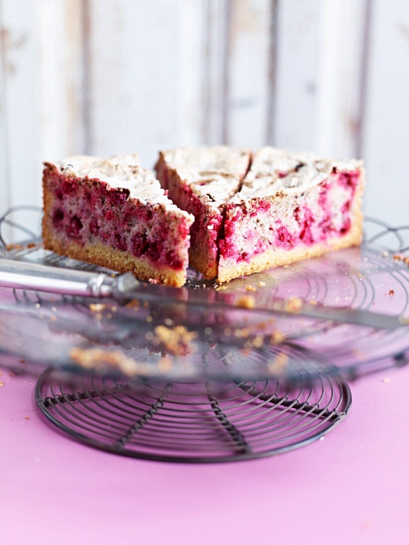 Three slices of redcurrant cake with meringue on a cake stand