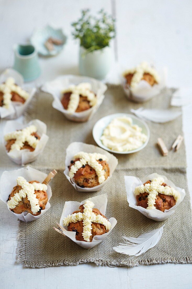 Hot Cross Buns Muffins dekoriert mit Frischkäsecreme zu Ostern