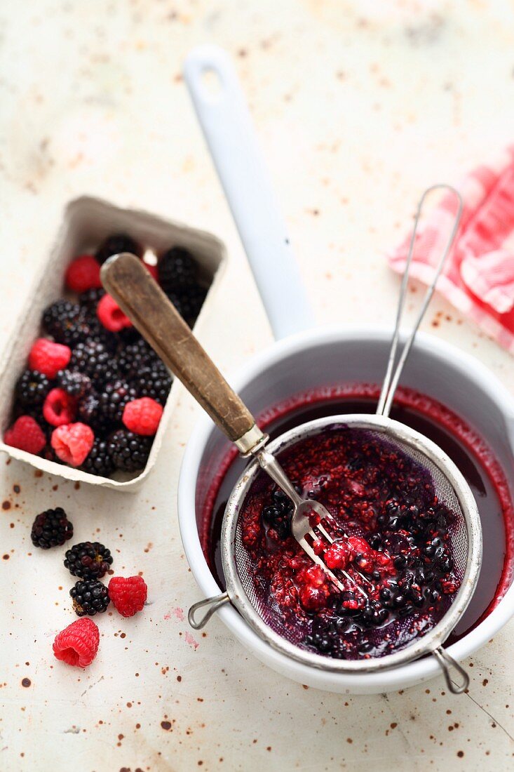 Frische Beeren durch ein Sieb passieren