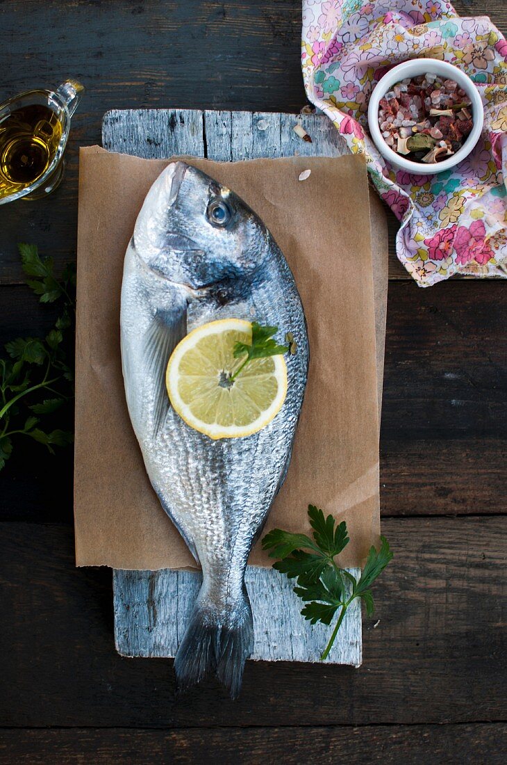 Gilt head seabream with olive oil, lemon slices, parsley and Himalayan salt