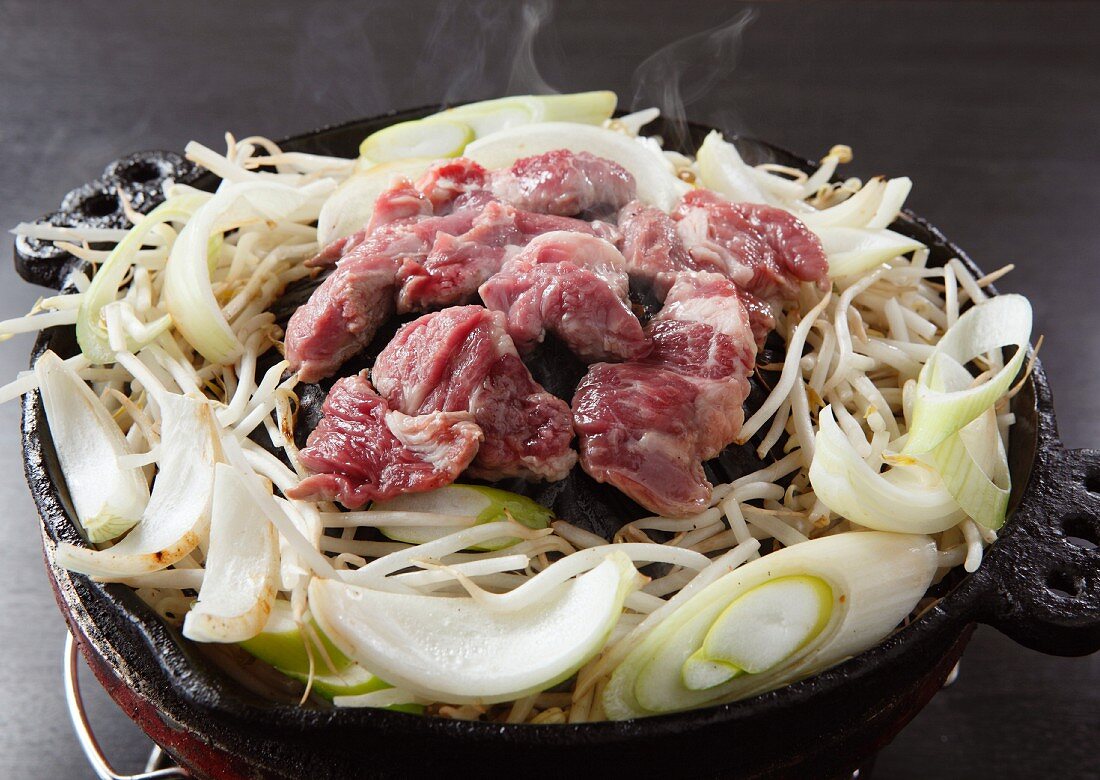Lamb with beansprouts and onions in a ceramic pot (Japan)