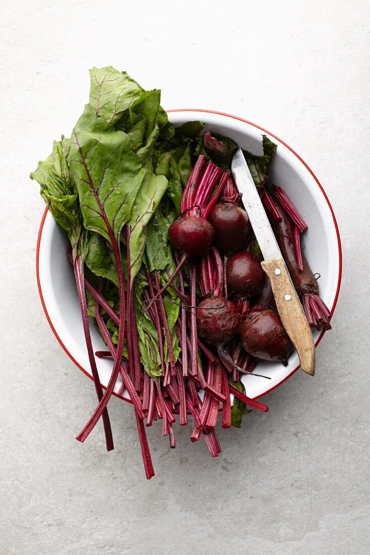 Beetroot leaves and beetroots in a bowl (seen from above)