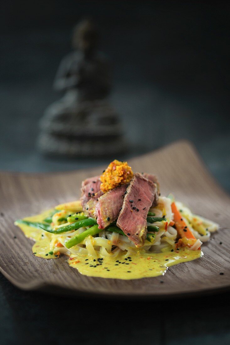 Beef fillets with wide rice noodles and curry sauce (Asia)