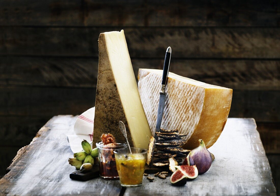 Two large slices of hard cheese with crispbreads and chutney on a rustic wooden table