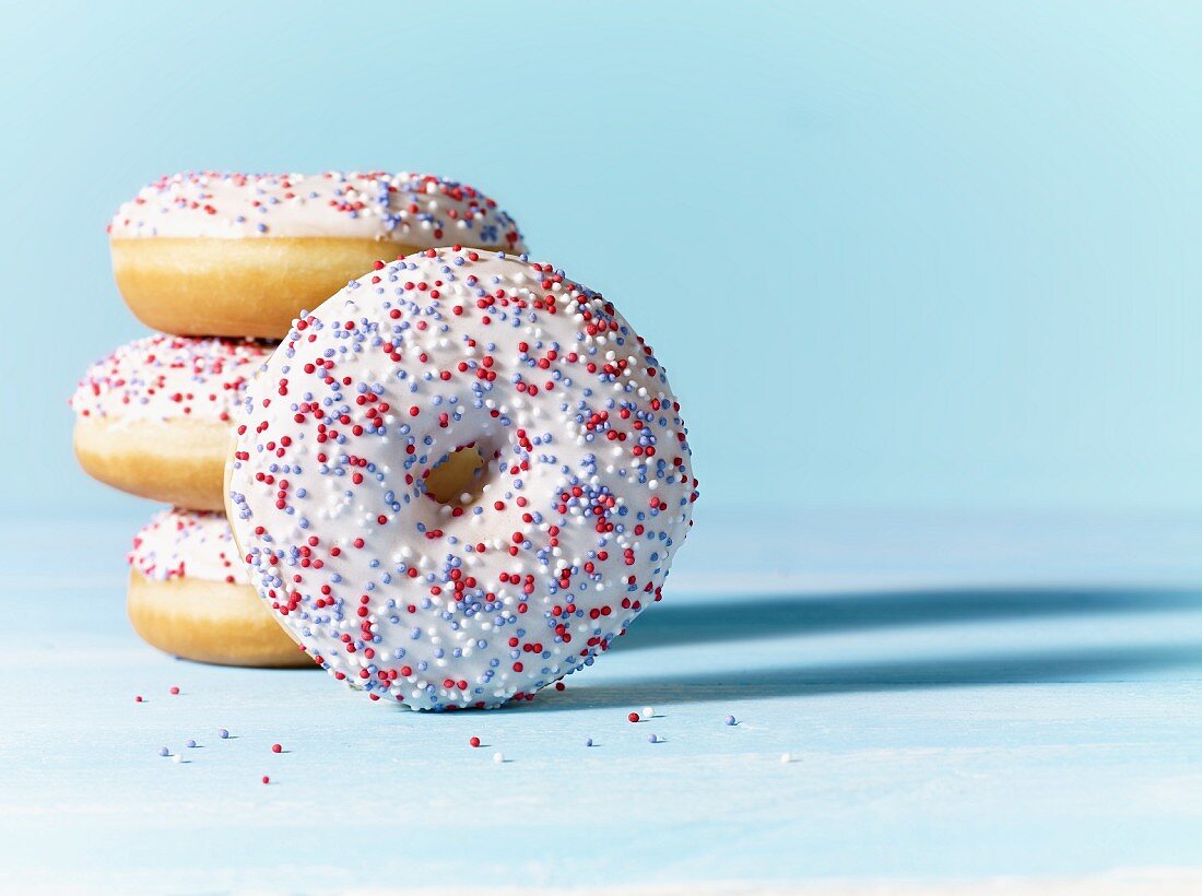 Doughnuts with white icing and colourful sugar sprinkles