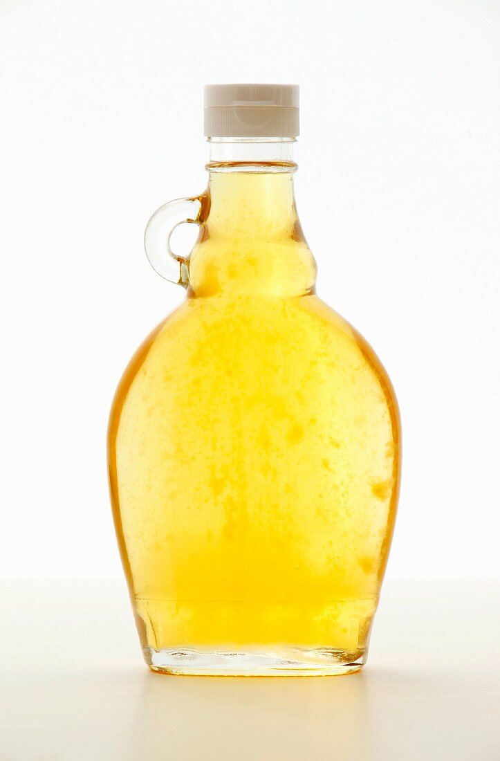Ginger syrup as a sugar substitute in a glass bottle on a white surface