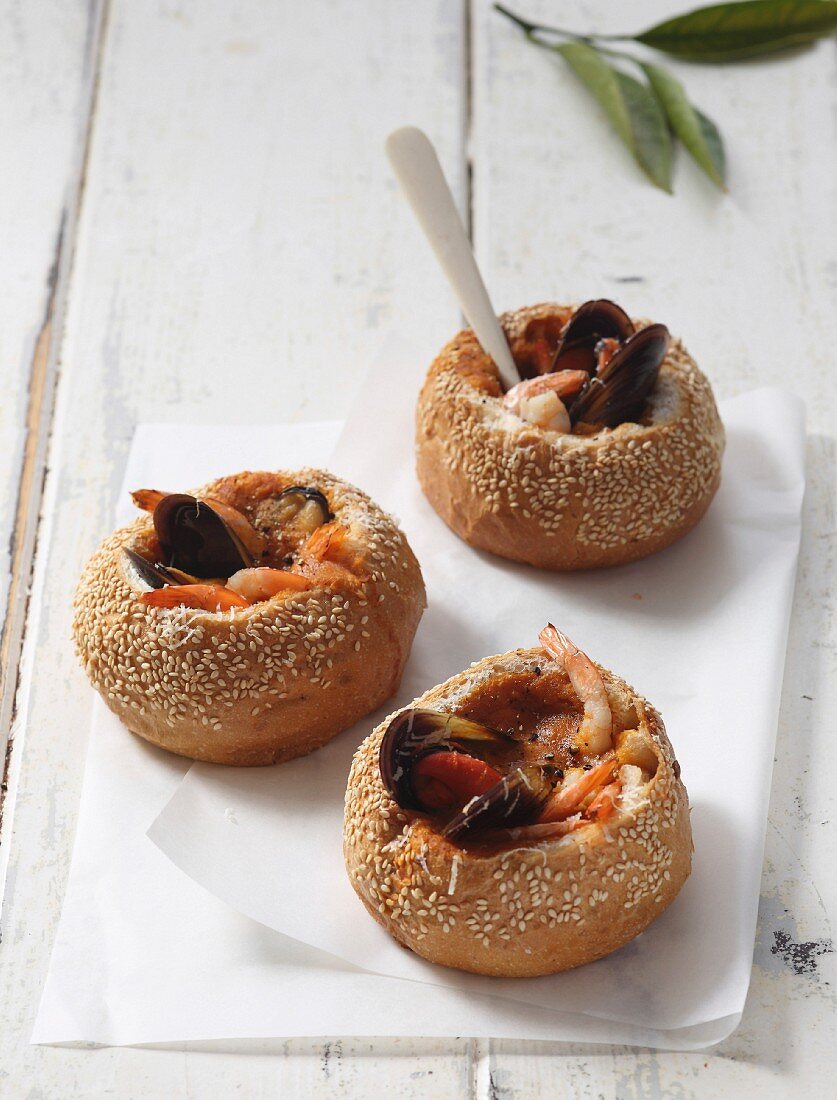 Seafood soup served in hollowed out sesame seed rolls