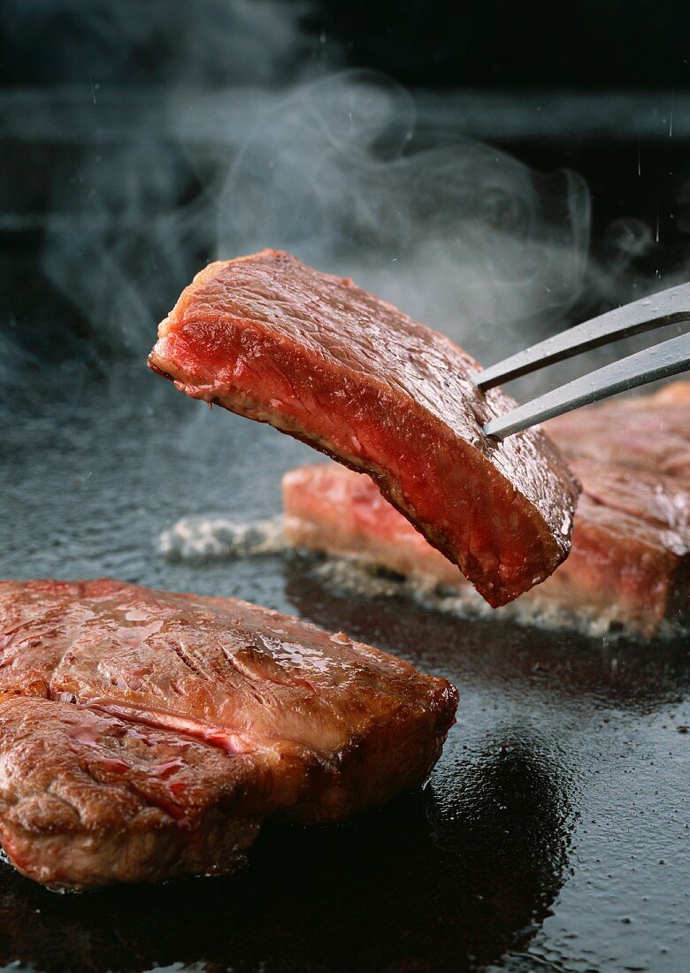Sirloin steaks being fried