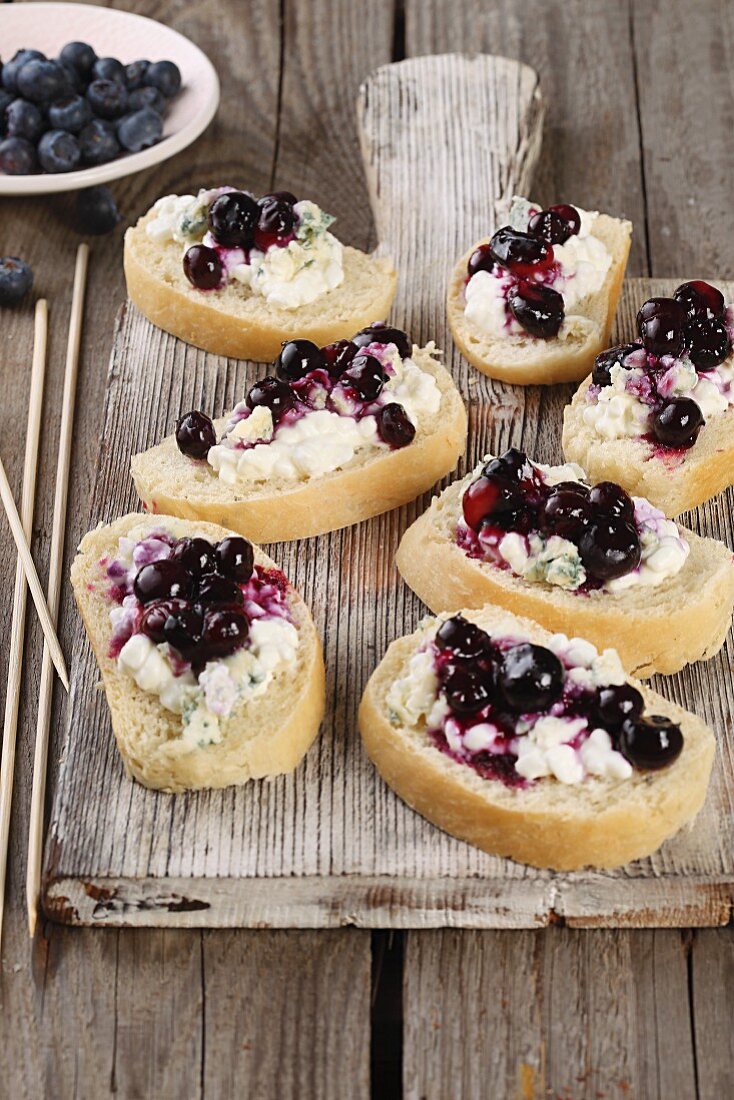 Baguette canapés topped with Gorgonzola cream and blueberries