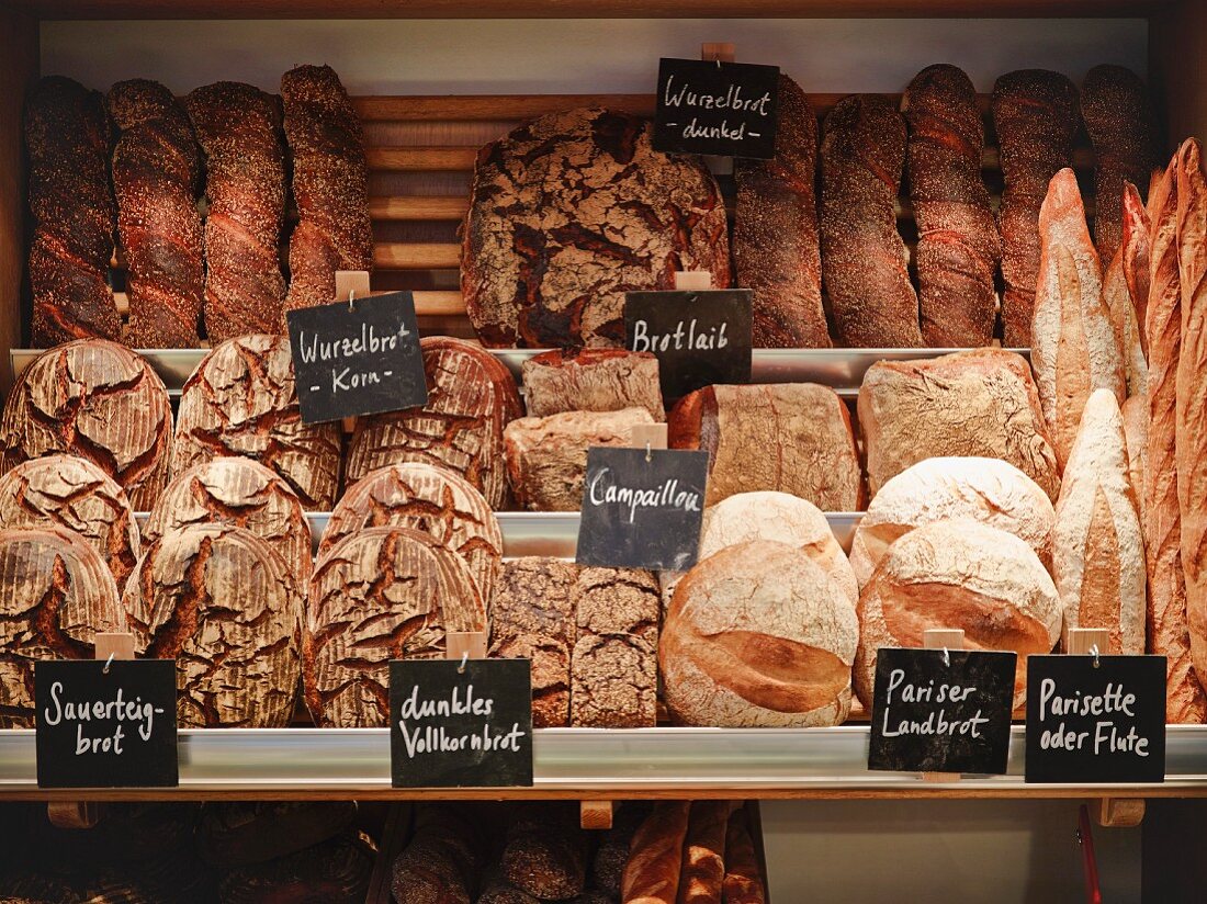 Various types of bread on shelves in a bakery