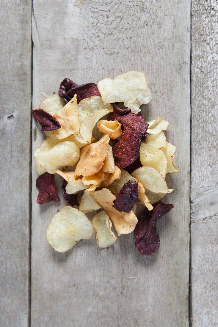 Kartoffelchips und Rote-Bete-Chips auf Holztisch