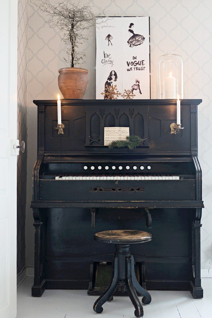 Altes schwarzes Klavier mit Kerzenbeleuchtung