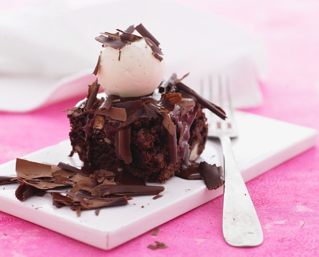Ein Stück Schokoladenkuchen mit Vanilleeiskugel & Schokoladenspänen