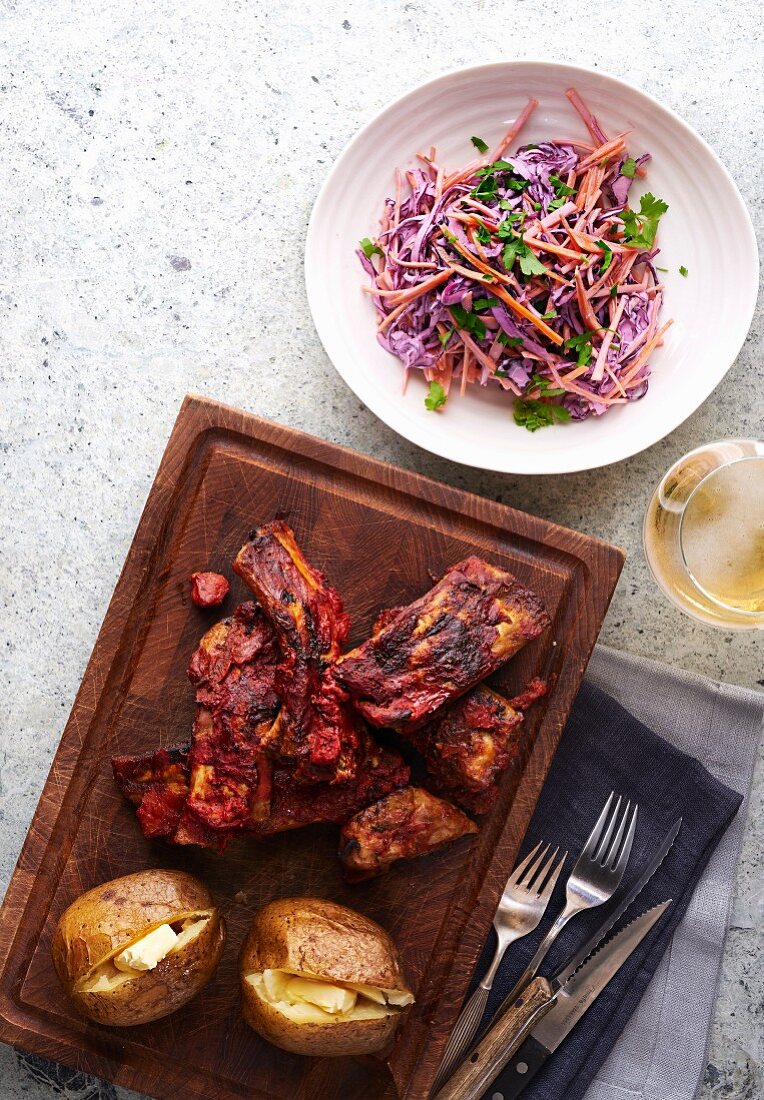 Spicy Cajun ribs with baked potatoes and coleslaw