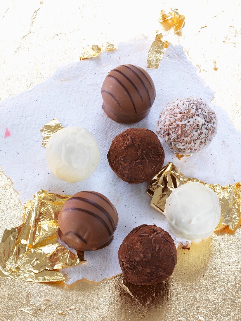 Various white and dark chocolate pralines with gold foil