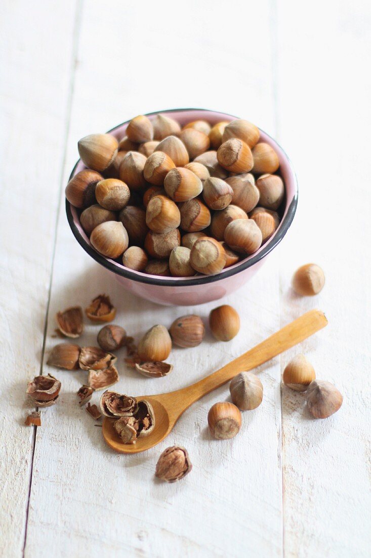 Hazelnuts in a bowl and next to it