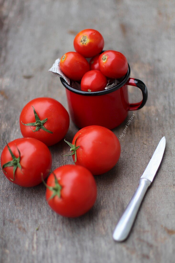 Tomatoes with a knife on a wooden surface
