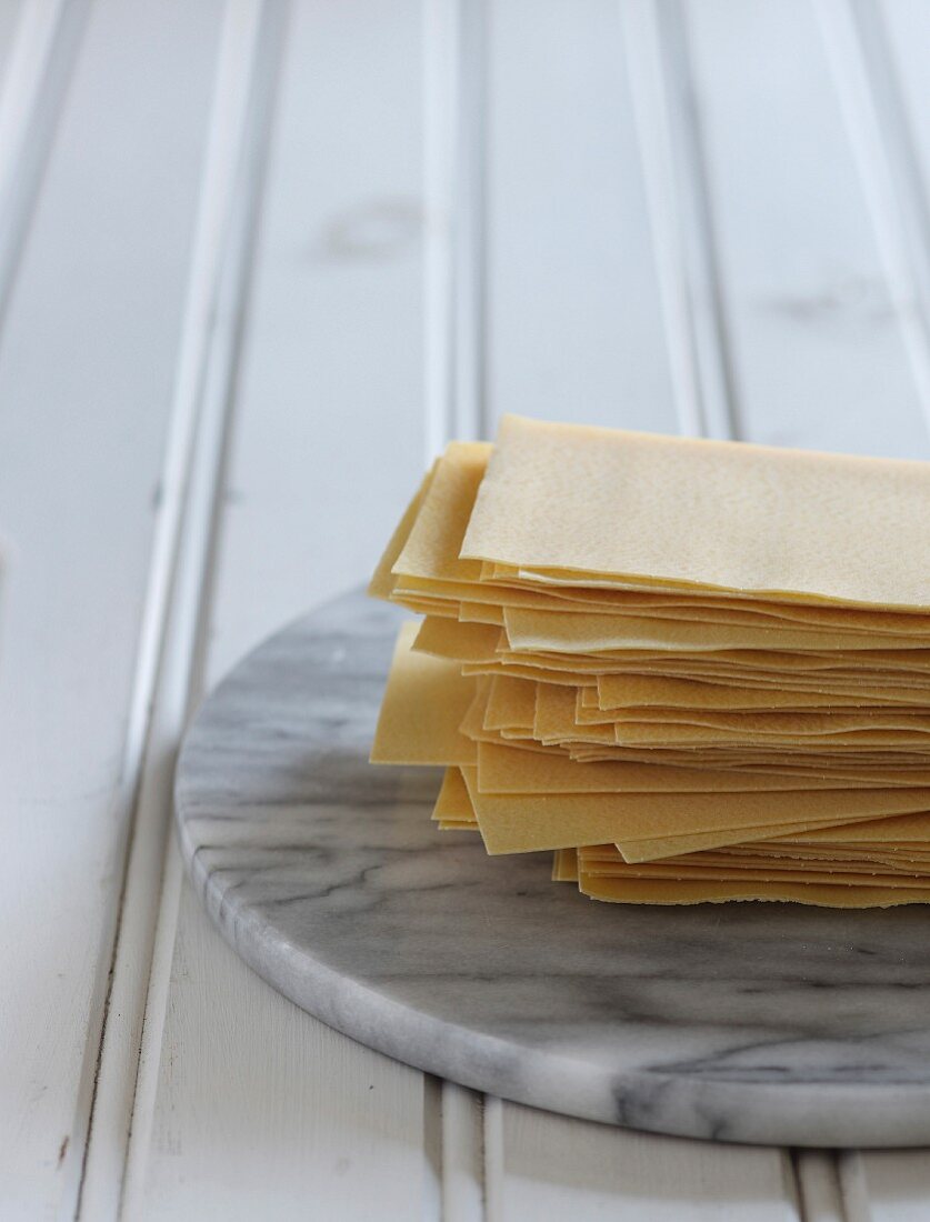 Gestapelte Lasagneblätter auf Marmorplatte