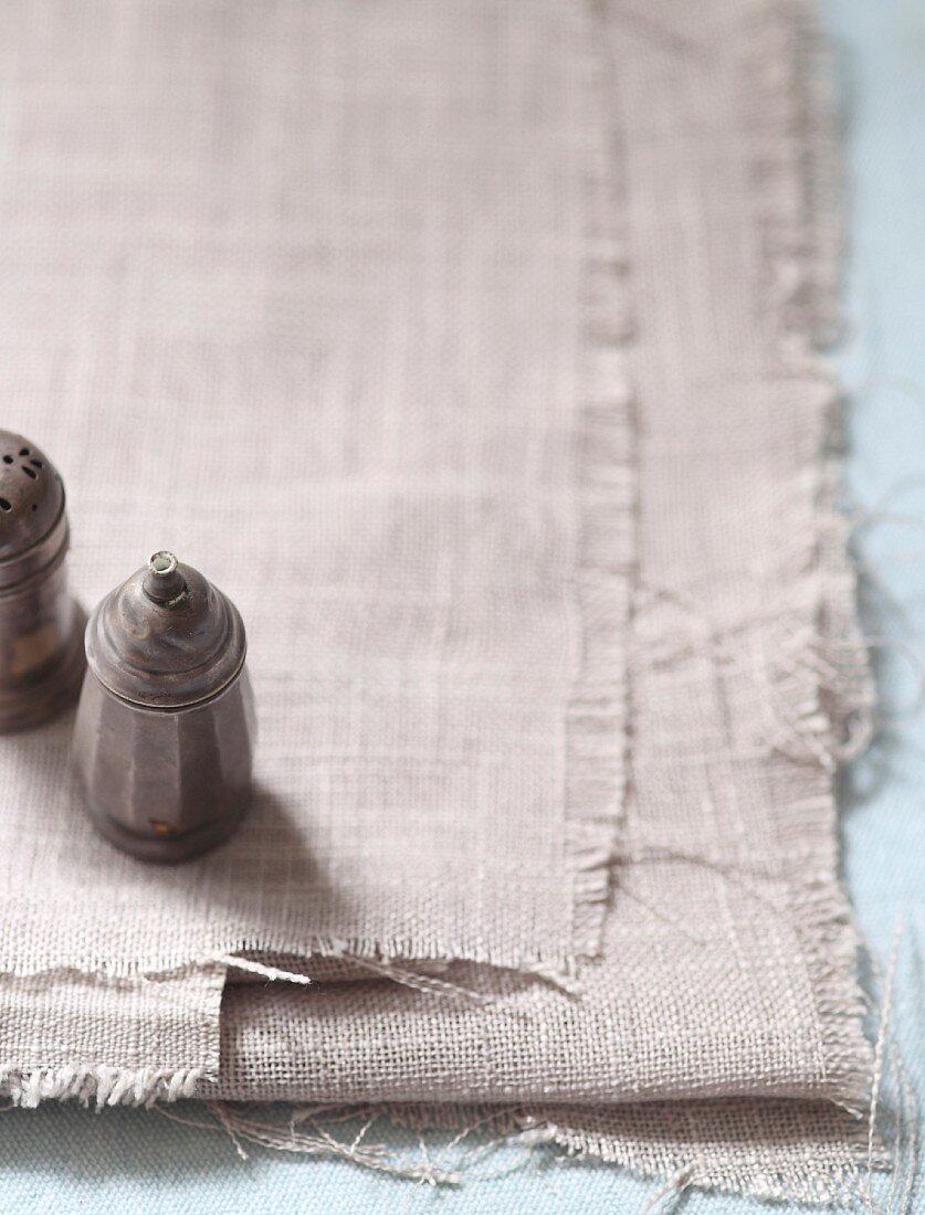 Salt and pepper shakers on a light linen cloth