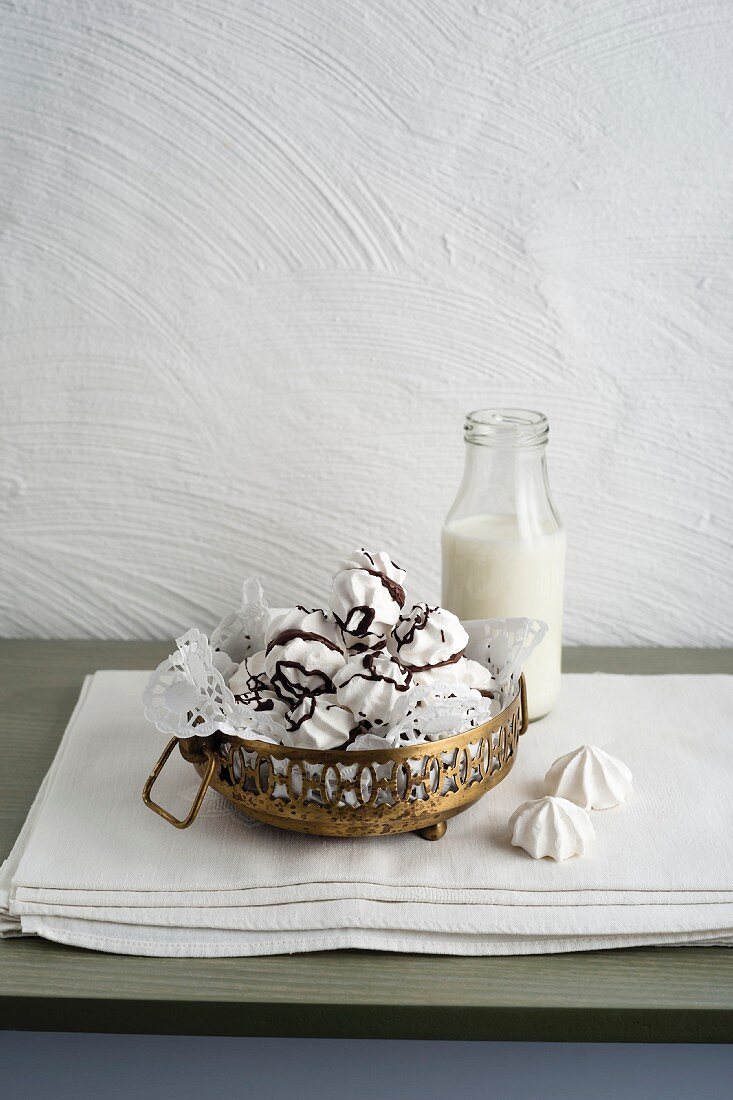 Baiser mit Schokoladenglasur daneben eine Flasche Milch